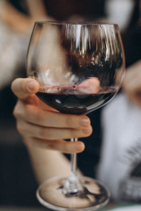 Glass or red wine being held in a hand
